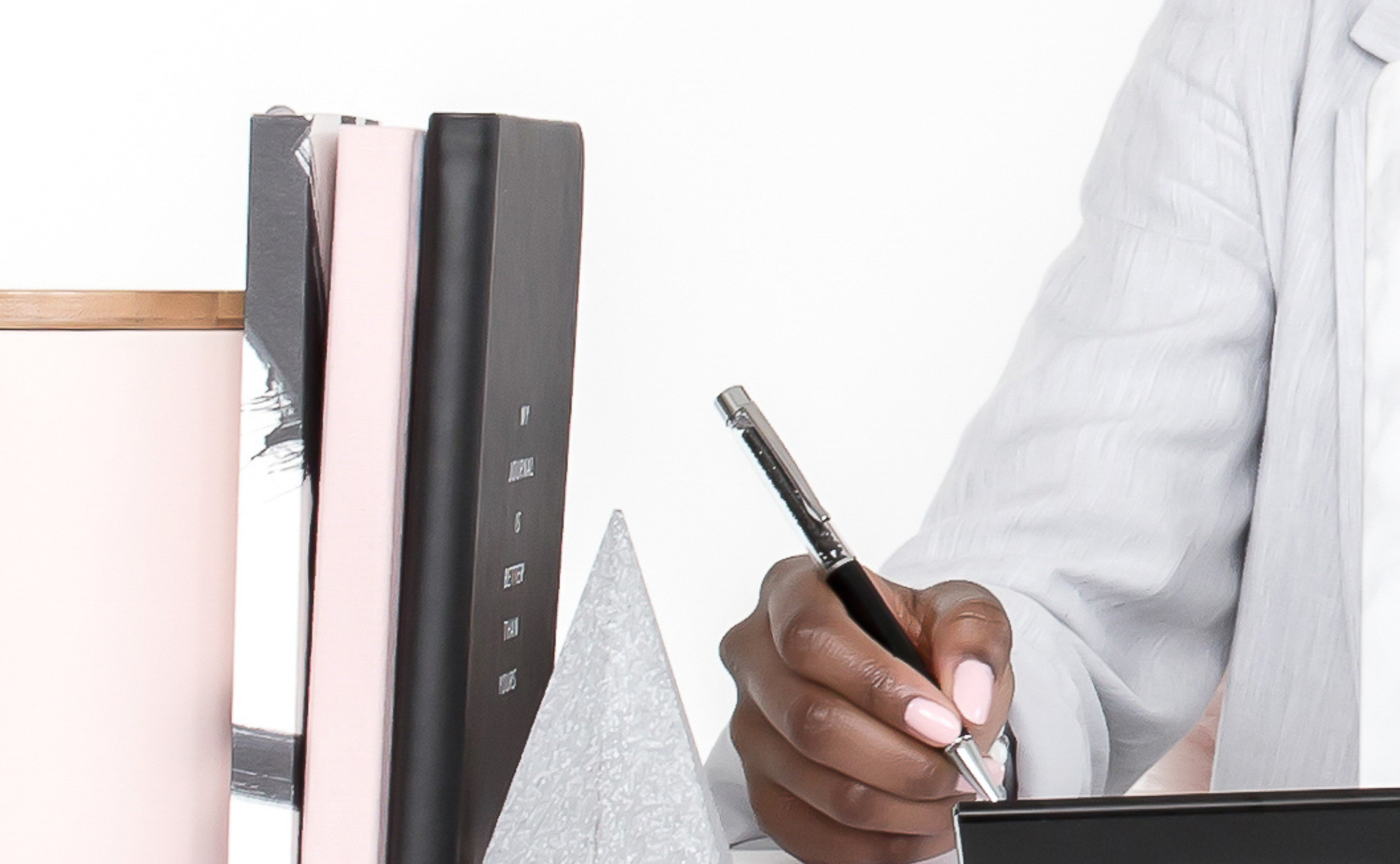 Woman sitting at desk with notebook and pen for blogging notes